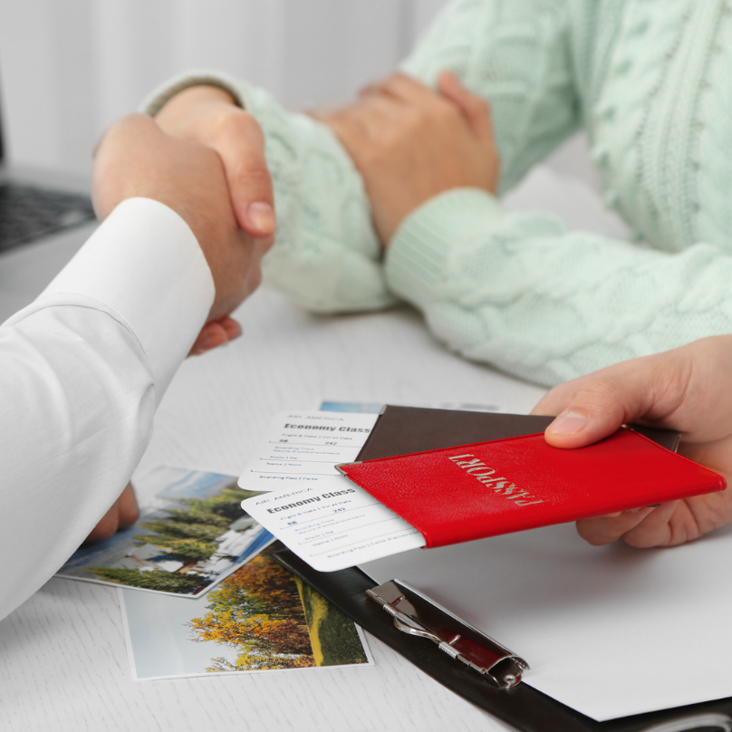 Discussing travel arrangements with documents on a desk